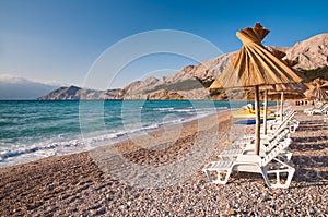 Sunshade and deck chair on beach at Baska in Krk - Croatia