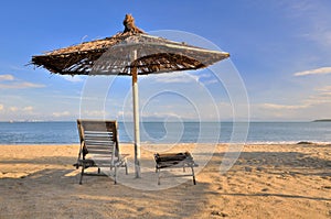 Sunshade and rest chair on sea sand