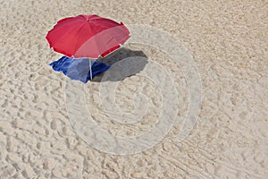 Sunshade and towel on empty beach