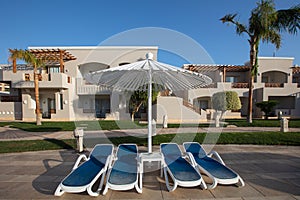 sunshade umbrellas and sunbeds near pool in Jaz Casa Del Mar Resort in Hurghada, Egypt