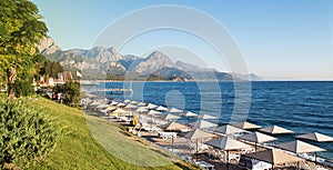 Sunshades and chaise lounges on beach. Turkey, Kemer.