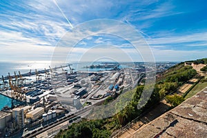 Sunshine on Balearic sea & Barcelona industrial shipping and rail ports on a blue-sky sunny day.
