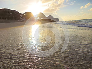 Sunshine on the beach reflections on wet sand