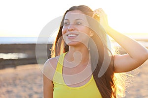 Sunshine girl at sunset. Beautiful smiling young woman enjoy life walking on empty beach at sunset
