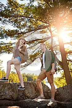 Sunshine, hiking and couple walking with trees, nature and adventure holiday in outdoor park. Trekking, man and woman on