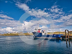 In sunshine, the interisland car ferry MV Filla moored at Symbister on the island of Whalsay