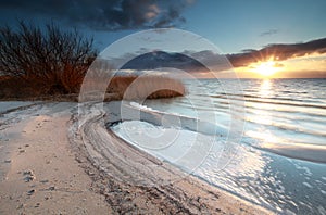 Sunshine over beach on lake Ijsselmeer