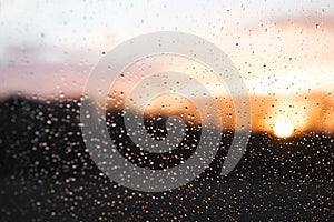 Sunset behind windowglass with raindrops