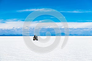 Sunshine scenery of Salar de Uyuni in Bolivia with biker riding over