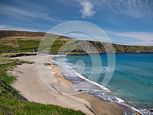 With sunshine on turquoise water, the pristine, deserted Norwick beach on the island of Unst, Shetland, UK