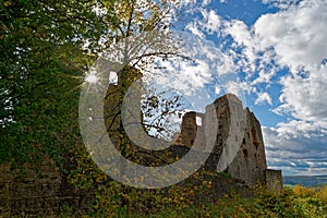 Sunstar in window of medieval castle ruin in autumnal landscape