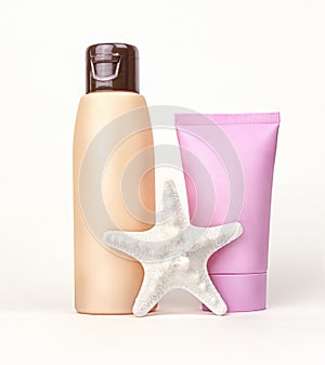 Suntan cream, sunblock lotion and seashell on white background