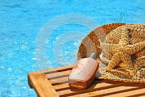 Suntan lotion and straw hat photo