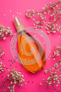 Suntan oil on a pink background. Uniform tan. A bottle of suntan oil . Protection of the skin. Vacation. Article about the choice