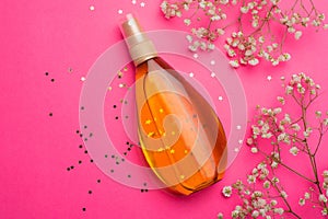 Suntan oil on a pink background. Uniform tan. A bottle of suntan oil . Protection of the skin. Vacation. Article about the choice
