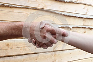 Suntanned male and female hands make handshake