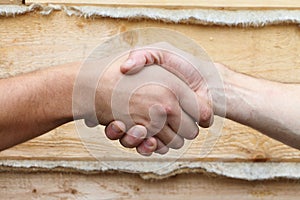 Suntanned male hands make handshake