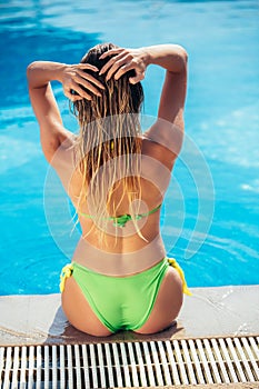 Suntanned young woman relaxing near swimming pool