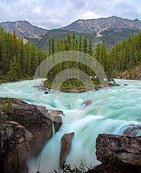 Sunwapta Falls with blue water flowing in Spring, Alberta, Canada photo