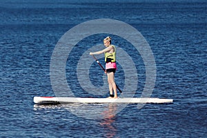 SUP fitness - woman on paddle board in the lake