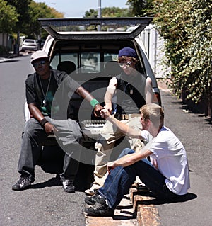 Sup homez. three young men hanging out on the side of the road.