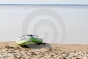 Sup paddle board lying on sand near beach lake water on the lakeside