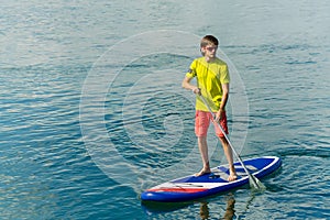 Sup surfing man stand up paddle boarder paddling at sunset on river