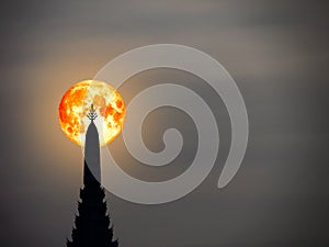 super blood moon in night sky and silhouette top of ancient pagoda