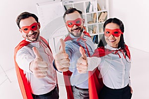 super businesspeople in masks and capes showing thumbs up