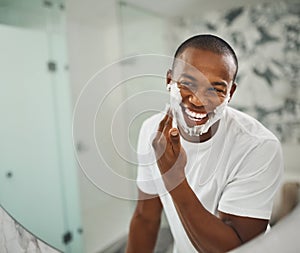 That super close shave for super soft skin. a handsome young man shaving his facial hair in the bathroom.