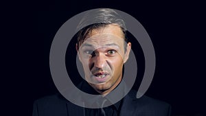 Super close-up of a man in black clothes on a black background. 4k. Slow motion.