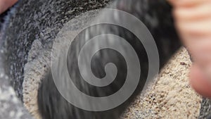 Super close-up of stone pestle mixing spices in the grey mortar