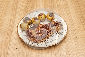 Super entrecote with sea salt and seasonal potatoes or cachelos on a white plate photo