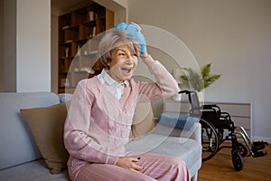 Super excited senior woman holding ice bag on head resting after injury