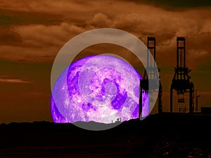 super full purple moon back mountain and silhouette crain at sea photo