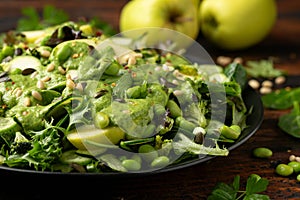 Super green salad with spinach, broccoli, apples, cucumber and edamame beans served with avocado, apple cider vinegar