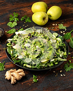 Super green salad with spinach, broccoli, apples, cucumber and edamame beans served with avocado, apple cider vinegar