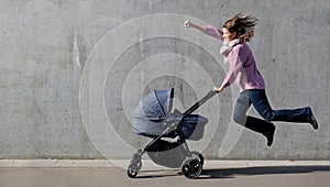 Super heroine mother flying with newborn stroller on grey concrete wall background. Strong powerful woman with baby carriage