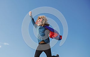 Super jump. Boy in red super hero cape and mask flying. Freedom, childhood, movement and child concept.