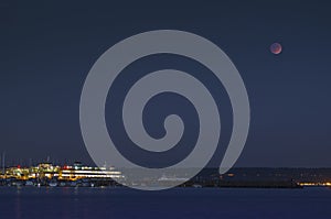 Super moon Lunar eclipse and ferry dock at night