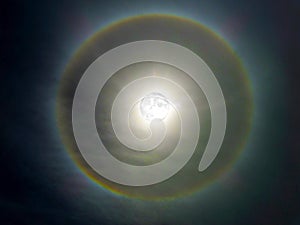 super moon and rainbow ring around in dark sky