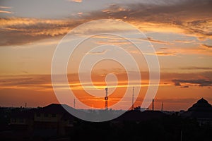 Super orange sunset with silhouettes of buildings and towers