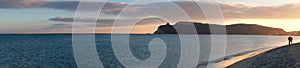 super panorama of the main beach of Cagliari (poetto sella del diavolo) with two walking lovers at sunset. Sardinia