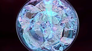 Super slow motion 1000fps top view on blue energy drink on red ice cubes in rotate glass.Slow motion pours blue energy