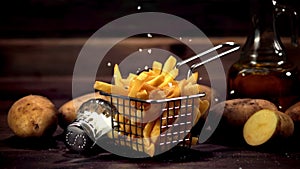Super slow motion in a basket of French fries pours salt. Filmed on a high-speed camera at 1000 fps.