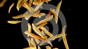 Super slow motion French fries flying in the air against a black background. Filmed on a high-speed camera at 1000 fps.