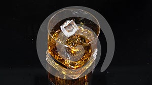 Super Slow Motion Macro Shot droping the ice into the glass with whiskey