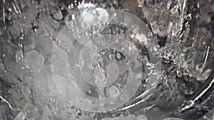 super slow-motion of water splashing in a washing machine, heavy interpolation artifacts in video