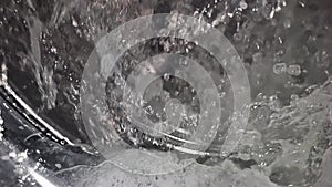 super slow-motion of water splashing in a washing machine, heavy interpolation artifacts in video