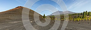 Super wide panoramic view of Volcano Arenas Negras and lava fields around. Bright blue sky and white clouds. Teide National Park